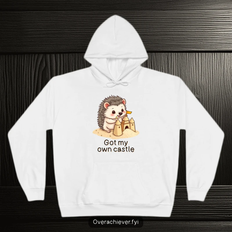 Funny Hedgehog Hoodie: A playful hedgehog building a miniature sandcastle with precise detail, offering humorous warmth and beachy charm.